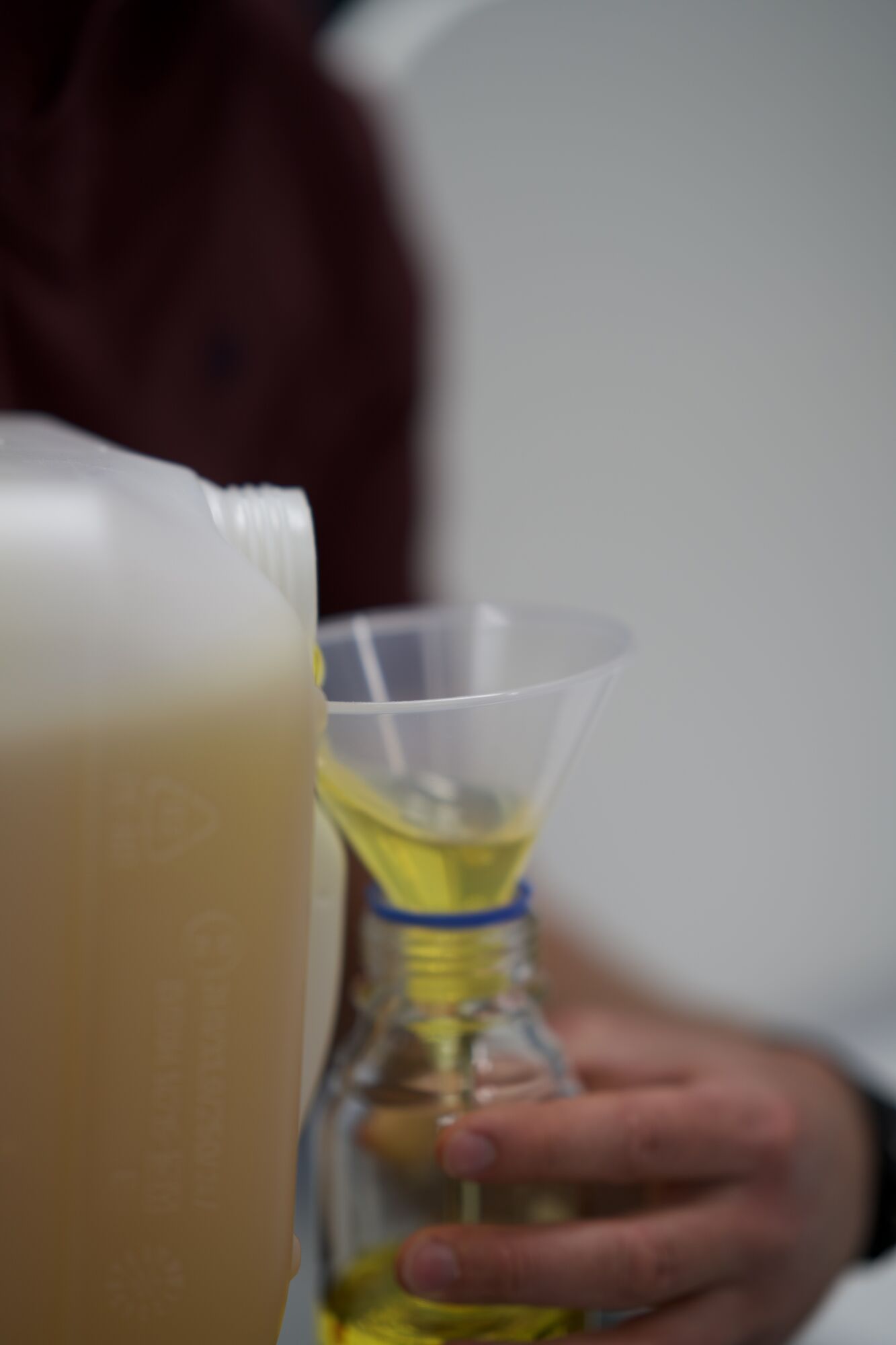 Amber liquid being poured into a sample bottle