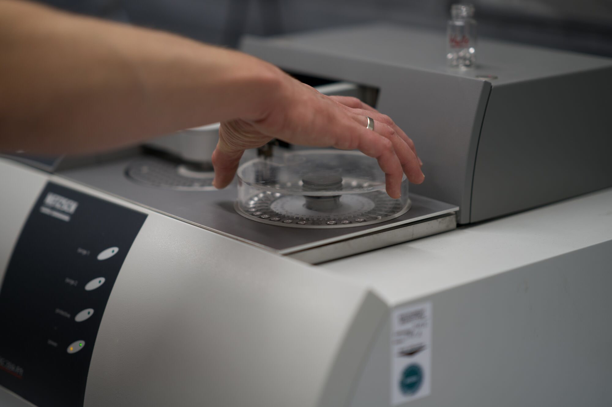 Technician placing a sample dish on a balance