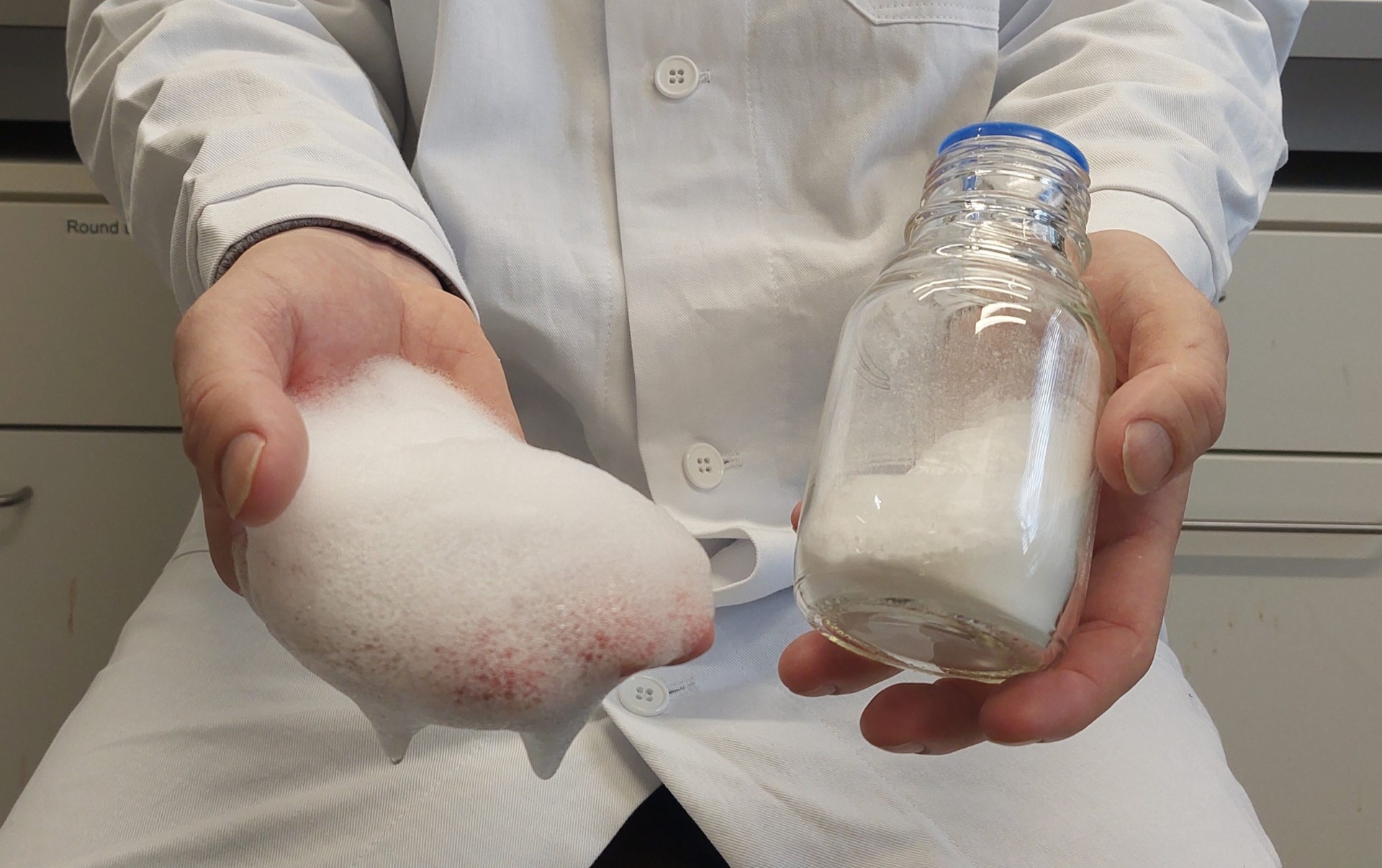 Scientist holding a surfactant sample and foam in their hands