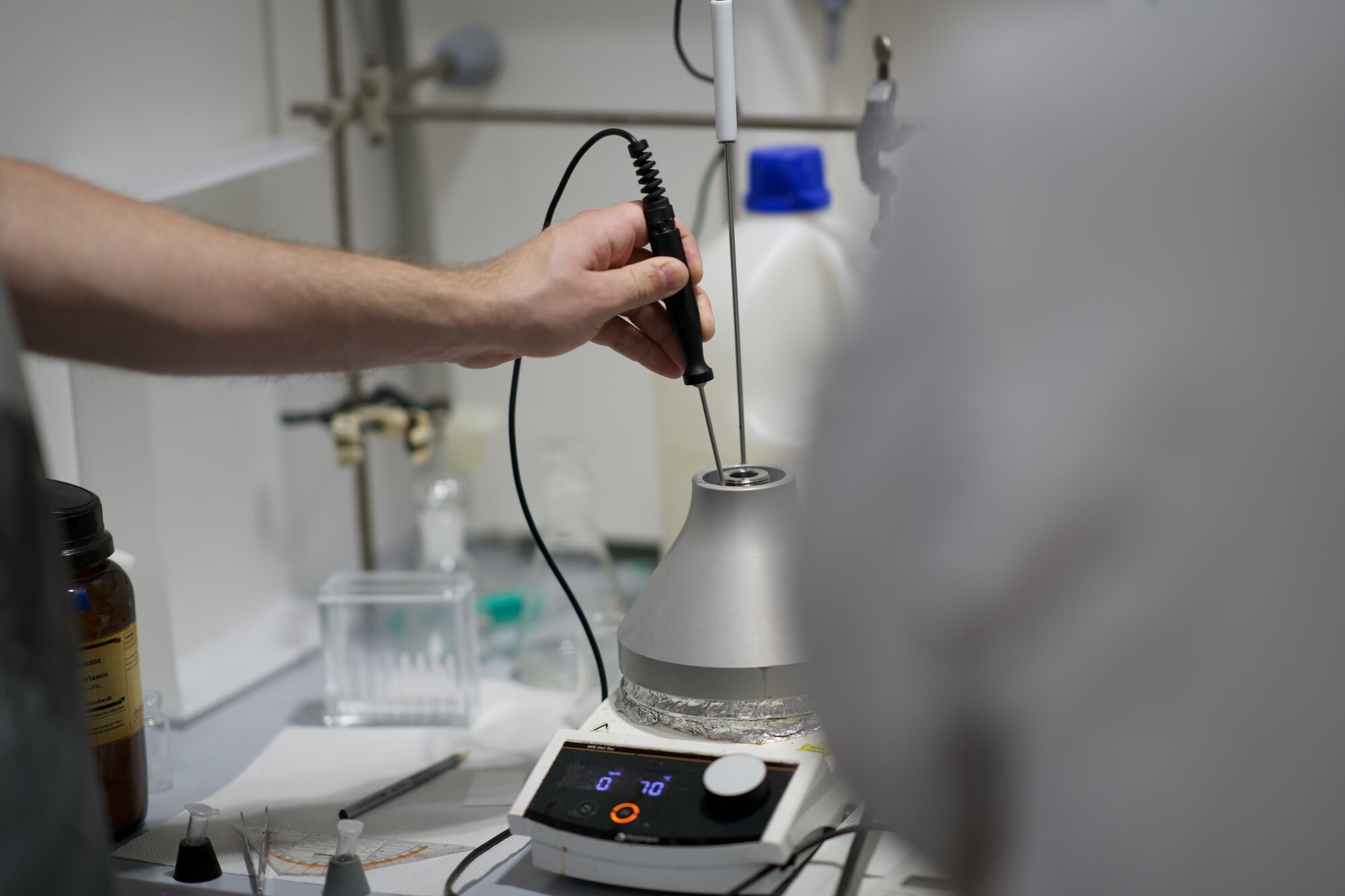 Chemist using an immersion homogenizer probe at the heating mantle