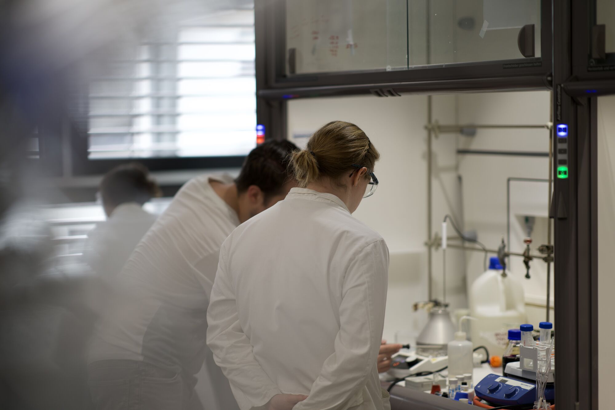 Two chemists working at the fume hood